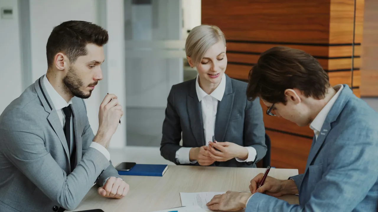 Three Claravance colleagues reviewing a document together at a meeting table